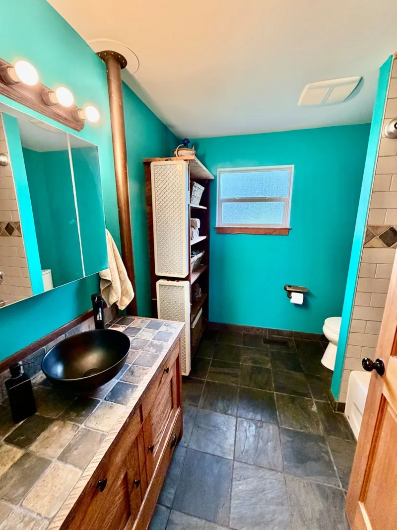 The main bathroom, in teal with a vessel sink